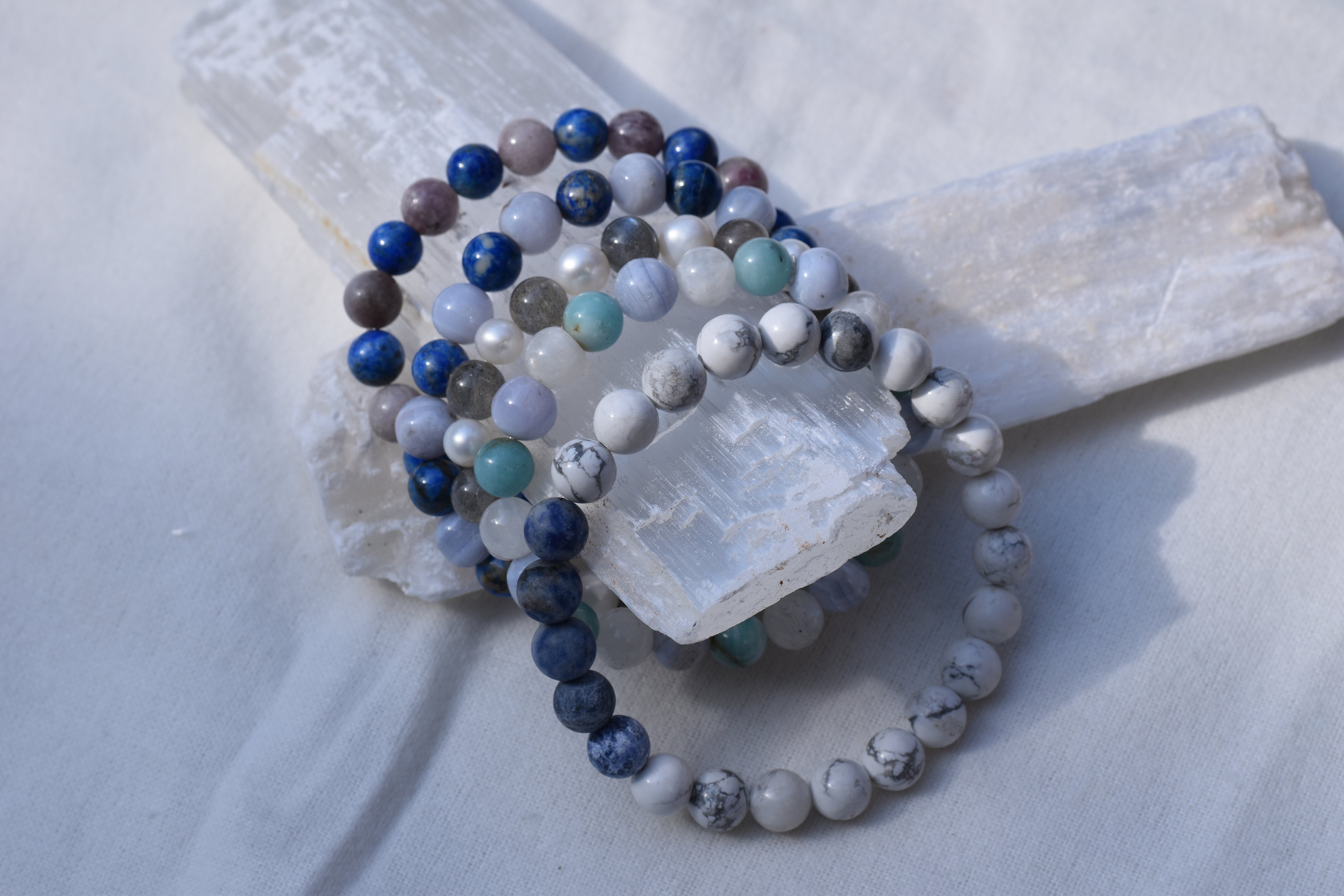stack of custom healing bracelets on two slabs of selenite