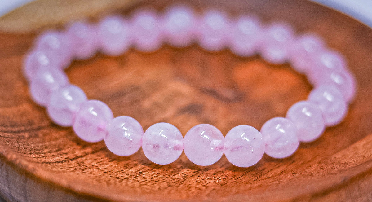 Current-stock Rose Quartz Bracelet 8mm photographed on wood