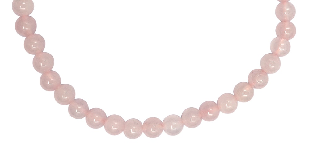 Close-up of the lower arc of a small round-bead rose quartz bracelet, showing pale-pink cloudiness and light reflections.